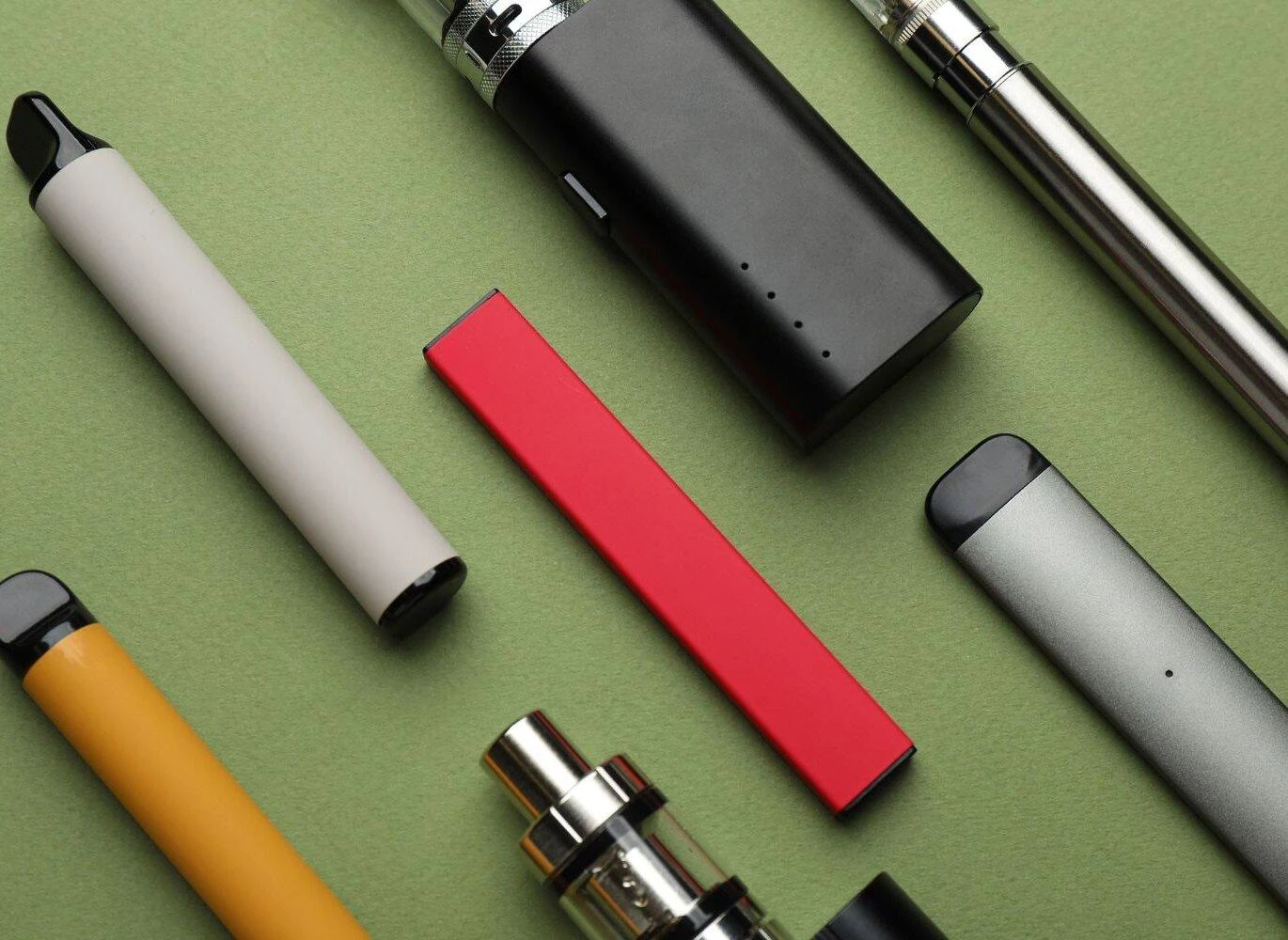 A collection of disposable, prefilled, and refillable vapes displayed side by side, illustrating the different types of e-vaporisers available.