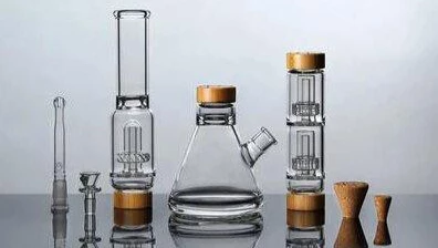 A variety of glass bongs arranged on a surface, showcasing their design and features in comparison to silicone bongs.