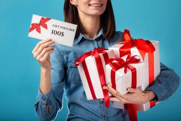 Woman Holding Retail Rewards Program Gifcards and Giftbox